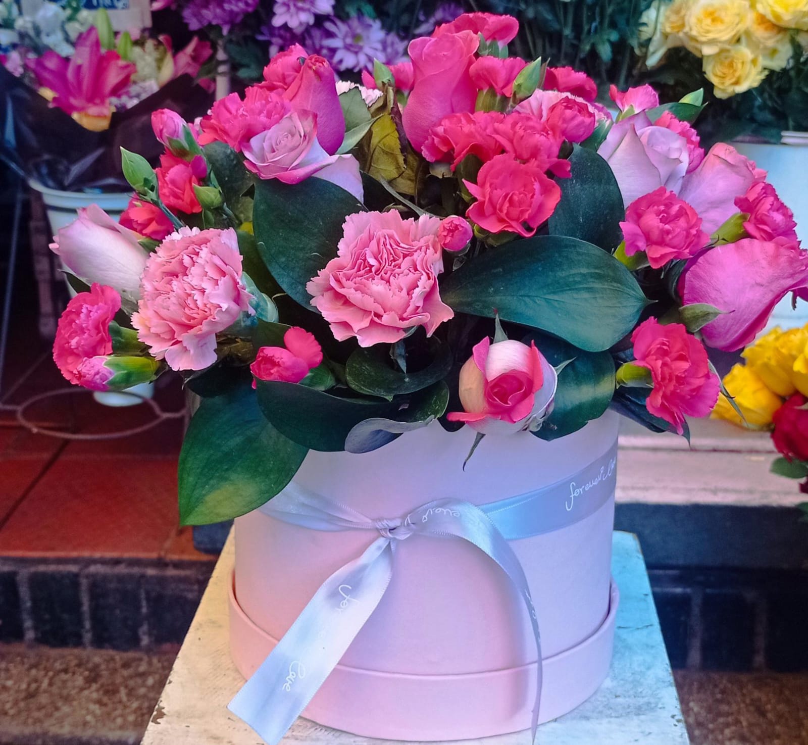 “Encanto Rosa – Caja floral con rosas y claveles”
